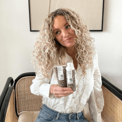Maria posing with scalp and face products