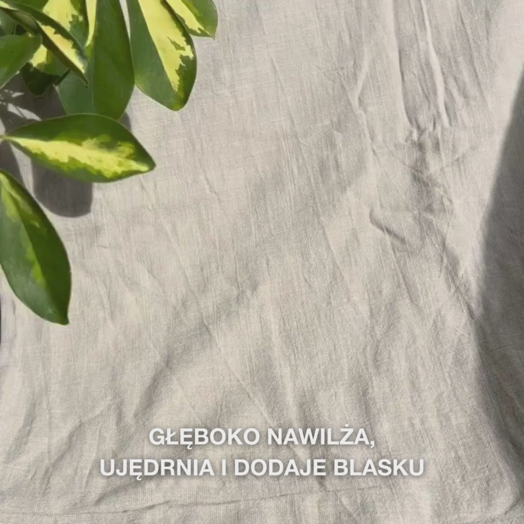 Zbliżenie na kobietę nakładającą intensywnie różową maskę na twarz z witaminą B12 i kolagenem na oczyszczoną skórę: rozprowadza ją na policzkach, czole i brodzie, podczas gdy kolagen i B12 nawilżają, ujędrniają, łagodzą i nadają promienny wygląd.