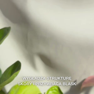 Zbliżenie na dłoń nanoszącą kilka cienkich kropli przezroczystego, lekkiego Peeling Serumu na opuszki palców, a następnie delikatnie wmasowując go w czystą skórę twarzy — jedwabista, płynna konsystencja widocznie usuwa martwe komórki, wygładza strukturę skóry i podkreśla blask dzięki naturalnym AHA (Lime Pearl), niacynamidowi i olejkowi z drzewa herbacianego 