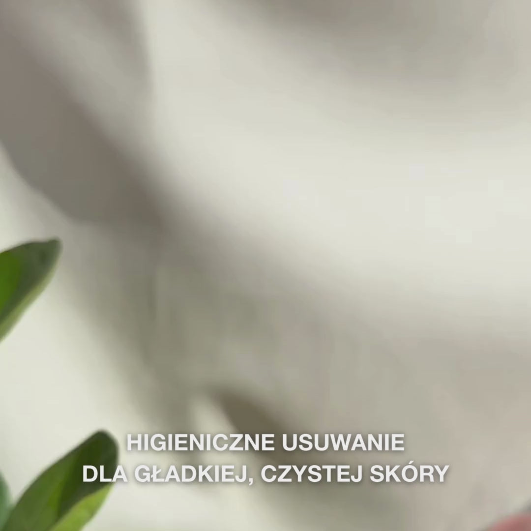 Zbliżenie dłoni używających dwustronnego narzędzia ze stali nierdzewnej do usuwania zaskórników na twarzy: mała metalowa pętelka delikatnie przyciskana jest wokół zaskórnika na nosie, pozostałości są wycierane, narzędzie jest spłukiwane, a następnie nakładany jest kojący tonik i krem do twarzy.
